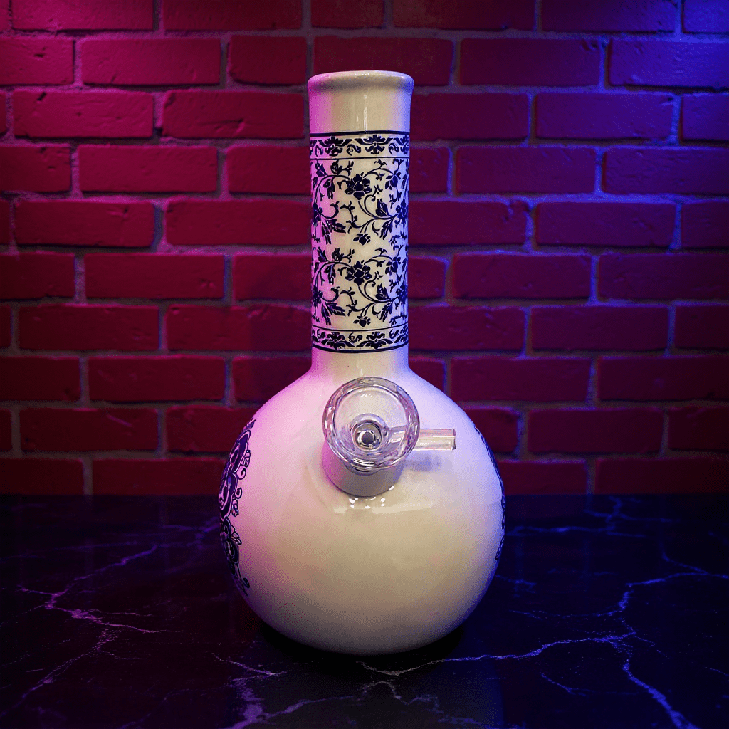 Blue Blossom Ceramic Bong – Vintage BongDecorative white ceramic bong with black floral patterns against a brick wall.