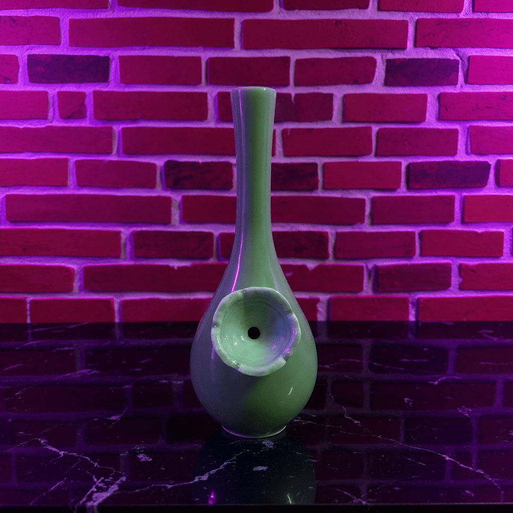Classic Green Celadon Porcelain Bong with Slim Neck DesignGreen ceramic bong with a unique design against a brick wall background