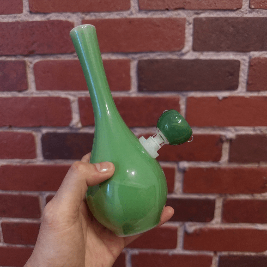Classic Green Celadon Porcelain Bong with Slim Neck DesignGreen ceramic bong with glass bowl held in front of a brick wall