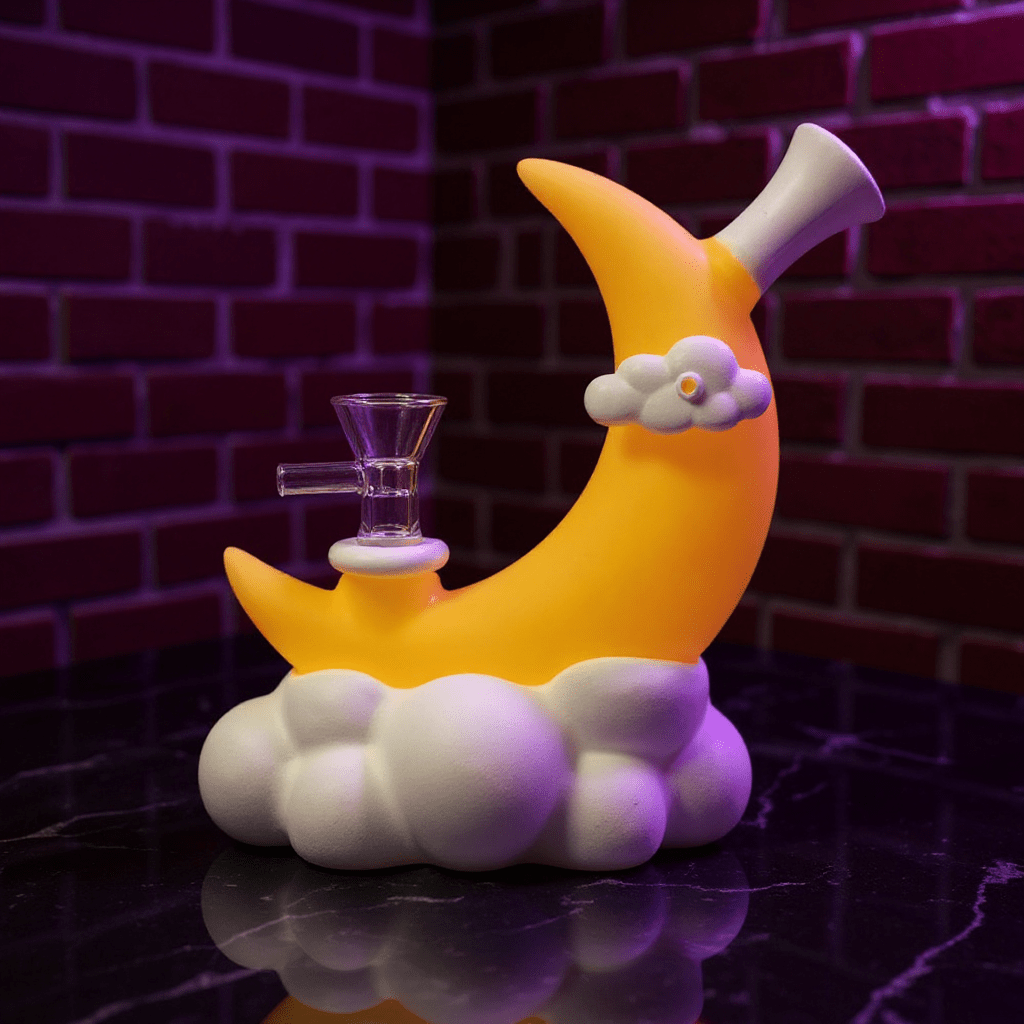☁️ CloudBreaker Water PipeNovelty banana - shaped silicone smoking pipe with moon and cloud design against a brick wall