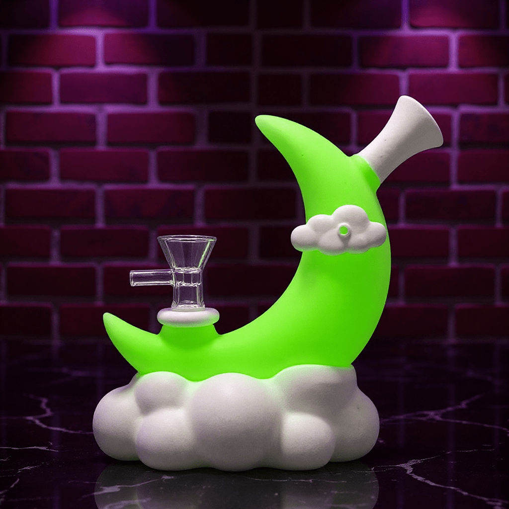 ☁️ CloudBreaker Water PipeGreen moon - shaped silicone bong with a cloud base on a dark surface against a brick wall