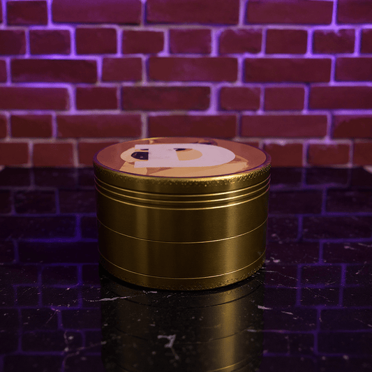 Doge Meme Herb Grinder - Gold - colored grinder with a doge meme design on a reflective surface against a brick wall.