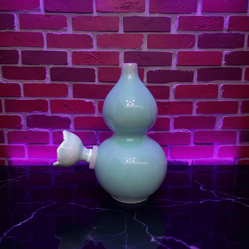Glossy Blue Celadon Gourd Porcelain BongGlossy Blue Celadon Gourd Porcelain Bong with ceramic bowl is placed on a marble surface.