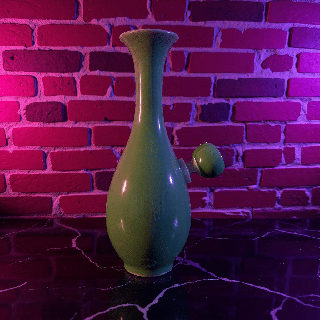 Glossy Green Celadon Bong with Flared TopFlared Neck Glossy Green Celadon Porcelain Bong with glass bowl is placed on a marble surface.