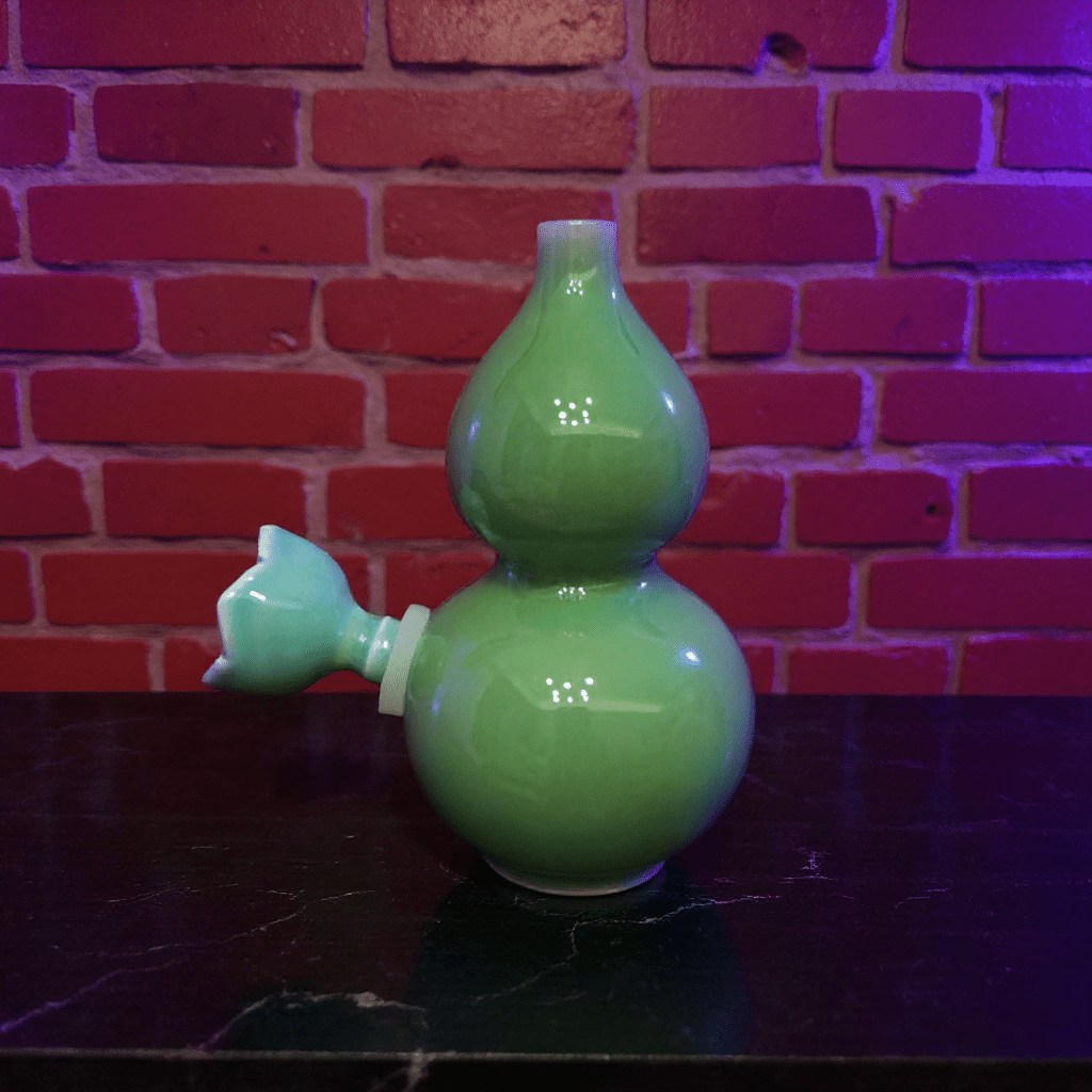 Glossy Green Celadon Gourd Porcelain BongGlossy Green Celadon Gourd Porcelain Bong with ceramic bowl is placed on a marble surface.