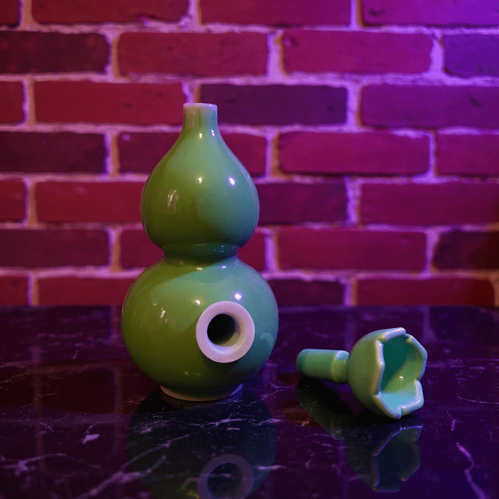 Glossy Green Celadon Gourd Porcelain BongGlossy Green Celadon Gourd Porcelain Bong and ceramic bowl are placed on a marble surface.