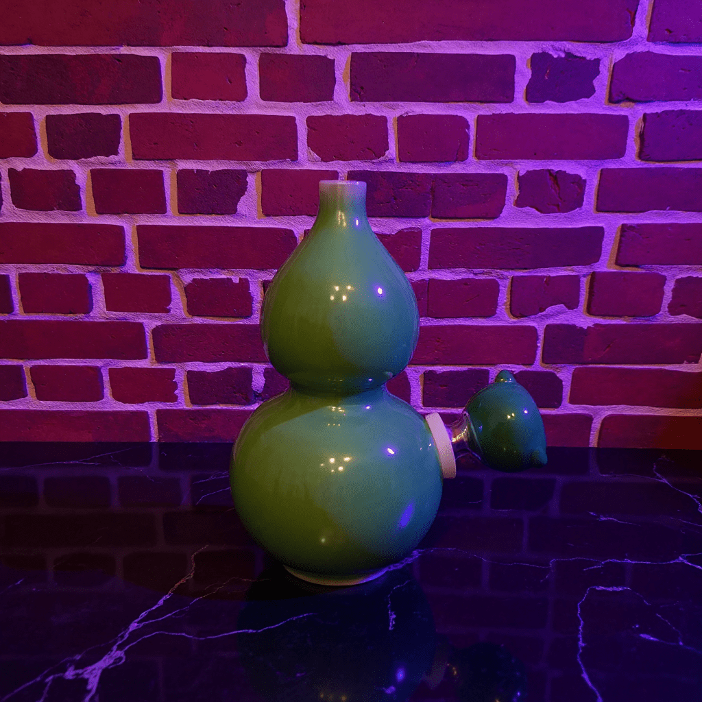 Glossy Green Celadon Gourd Porcelain BongGlossy Green Celadon Gourd Porcelain Bong with glass bowl is placed on a marble surface.
