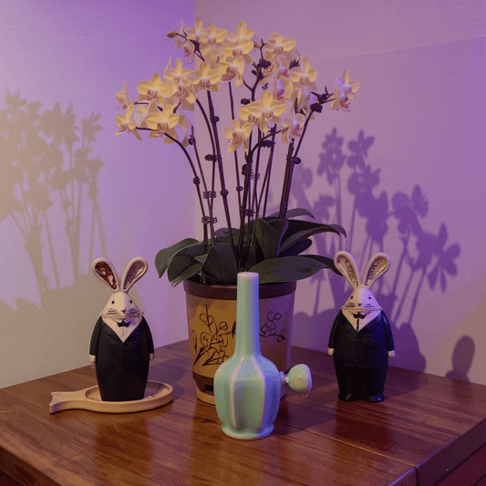 Glossy Light Blue Celadon Flat - Sided Porcelain BongGlossy Light Blue Celadon Flat - Sided Porcelain Bong with glass bowl is placed on a wooden surface.