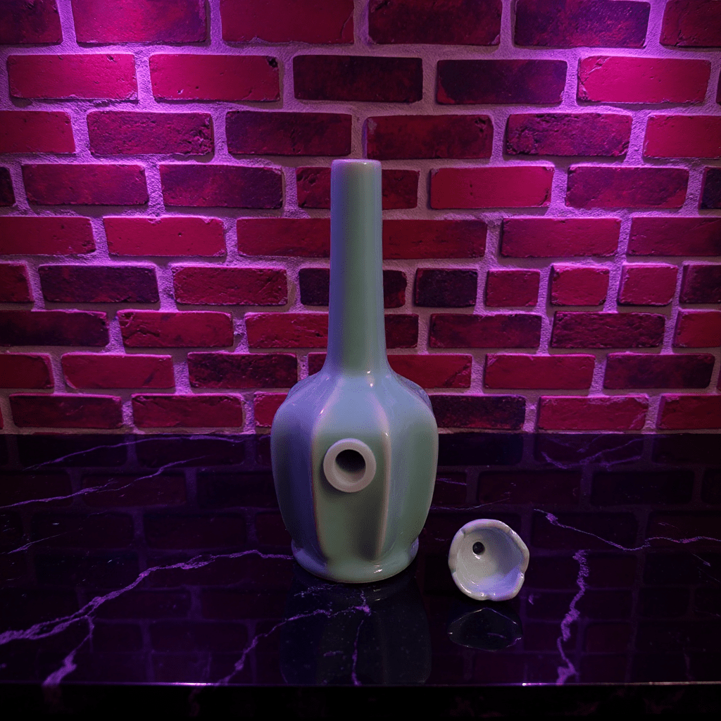 Glossy Light Blue Celadon Flat - Sided Porcelain BongGlossy Light Blue Celadon Flat - Sided Porcelain Bong and ceramic bowl are placed on a marble surface.