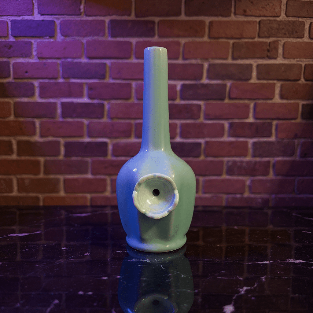 Glossy Light Blue Celadon Flat - Sided Porcelain BongGlossy Light Blue Celadon Flat - Sided Porcelain Bong with ceramic bowl is placed on a marble surface.