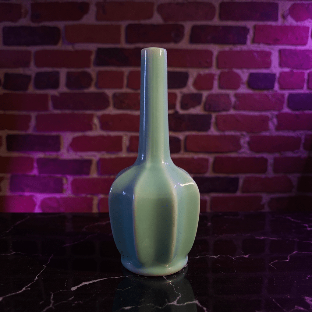 Glossy Light Blue Celadon Flat - Sided Porcelain BongGreen ceramic bong on a dark surface with a brick wall background