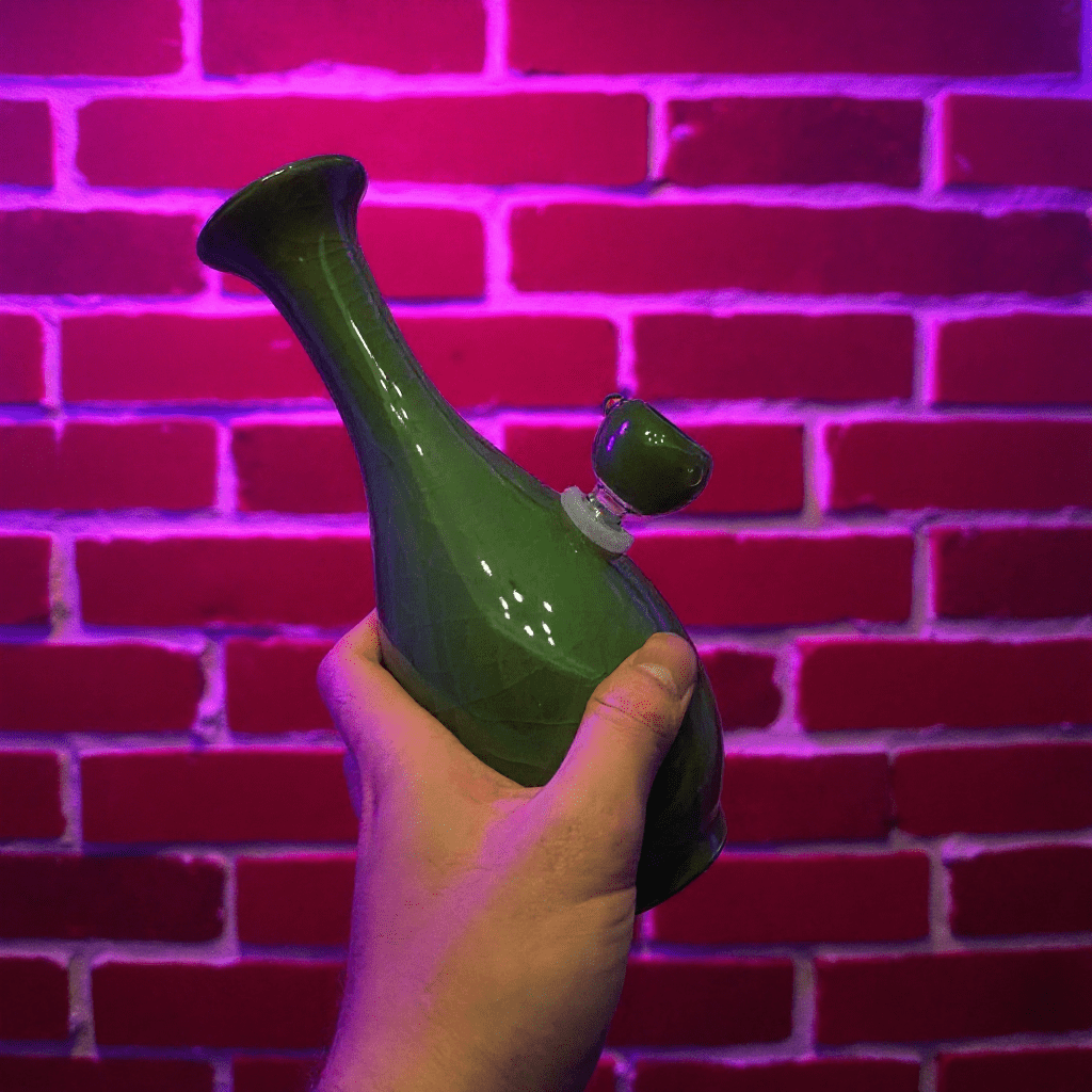 Green Ice - Crack Celadon Porcelain Bong with Flared TopGreen porcelain bong with glass bowl held in front of a red brick wall