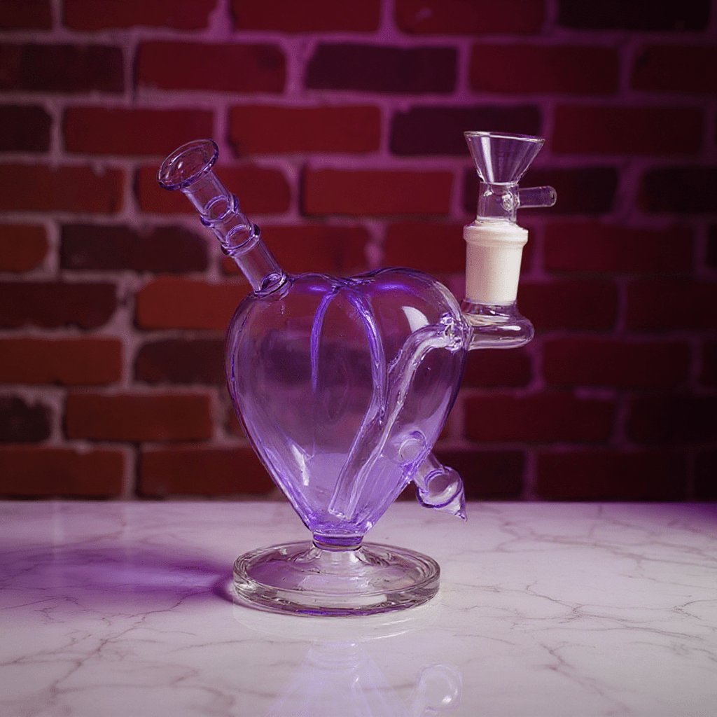 Heartpiercer glass bong - Purple VersionGlass heart - shaped smoking bong on a marble surface with a brick wall background