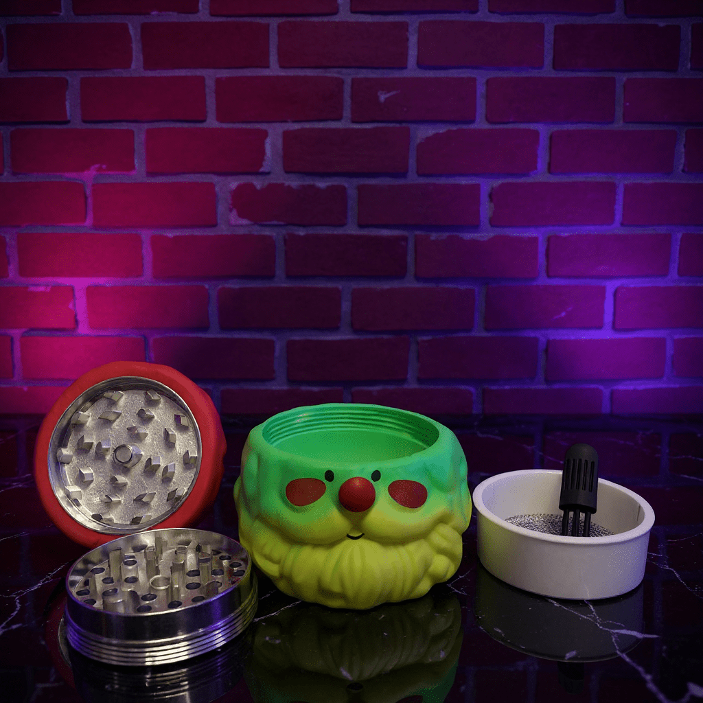 Herb Grinder – Holiday Edition Three smoking accessories on a reflective surface with a brick wall background