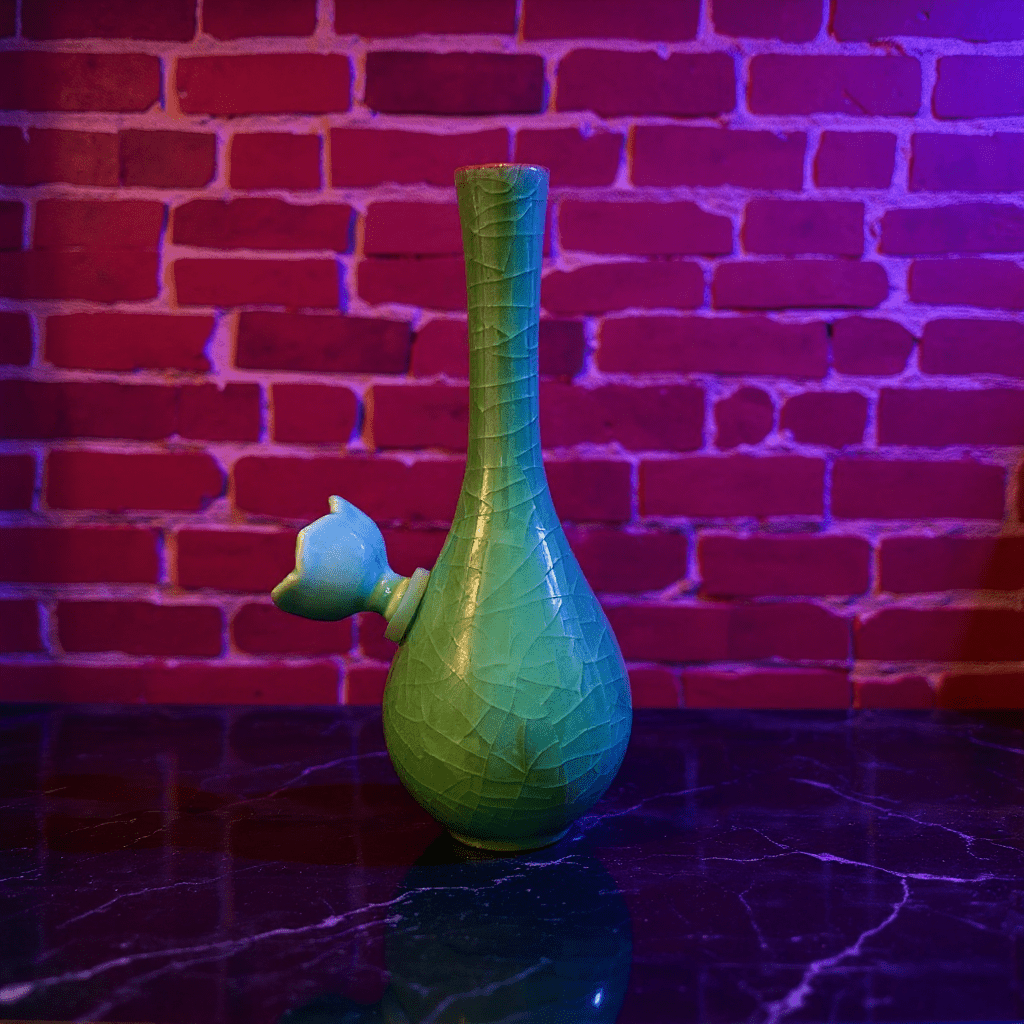 Ice - Crack Celadon Bong with Slim Neck Designslim neck ice - crack celadon ceramic bong with ceramic bowl is placed on a marble surface.