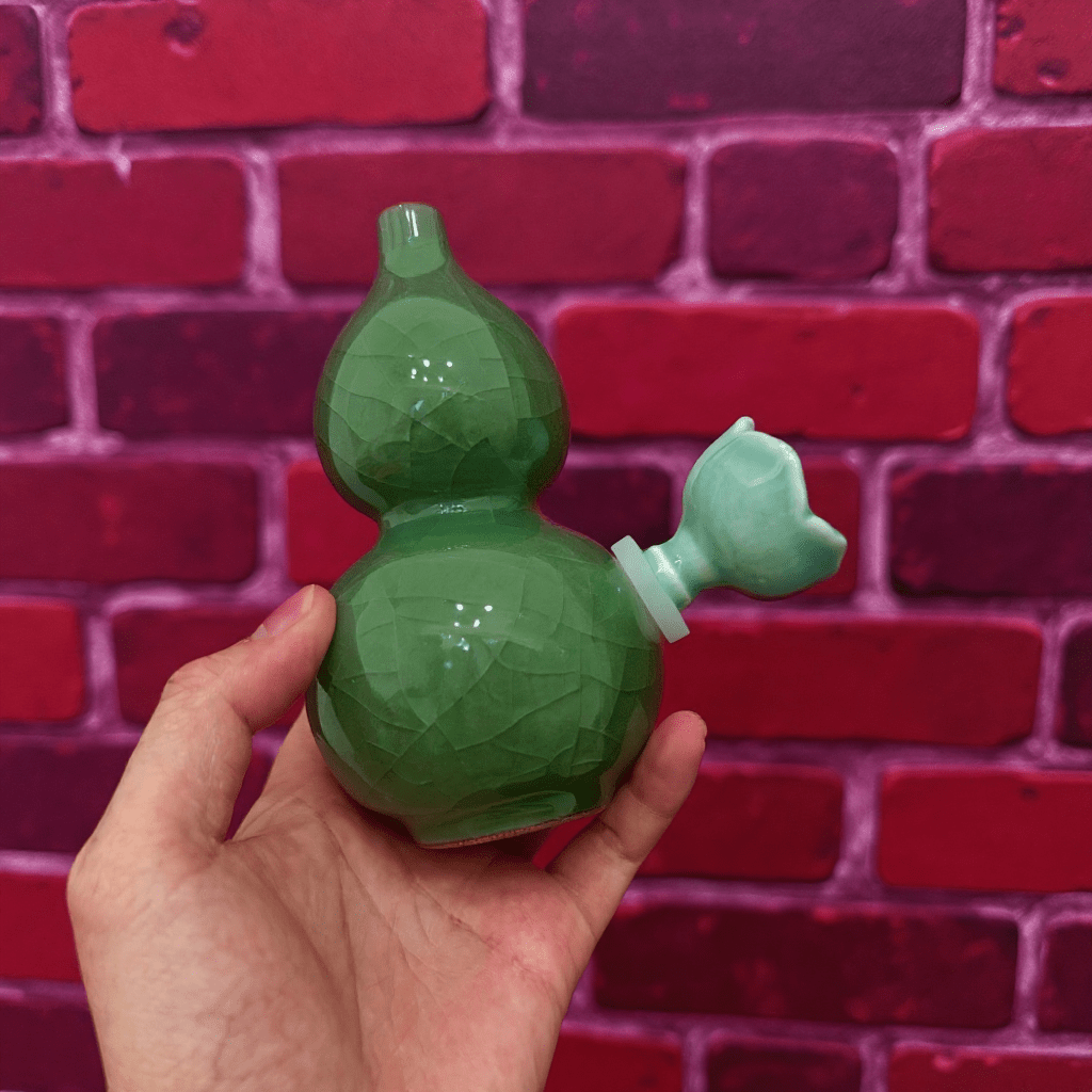 Ice - Crack Green Celadon Gourd Porcelain BongGreen porcelain bong with ceramic bowl held by hand in front of a red brick wall