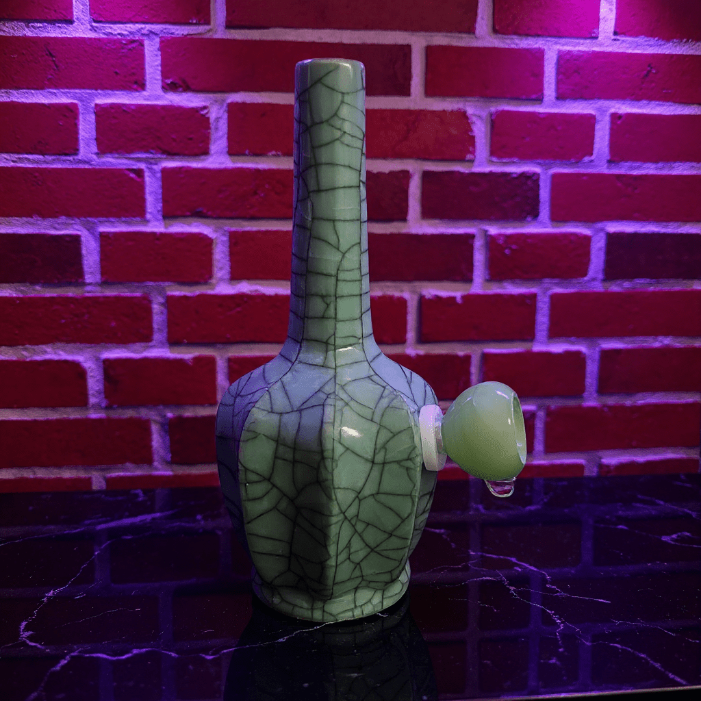 Ice - Crack Light Blue Celadon Flat - Sided Porcelain BongIce - Crack Light Blue Celadon Flat - Sided Porcelain Bong with glass bowl is placed on a marble surface.