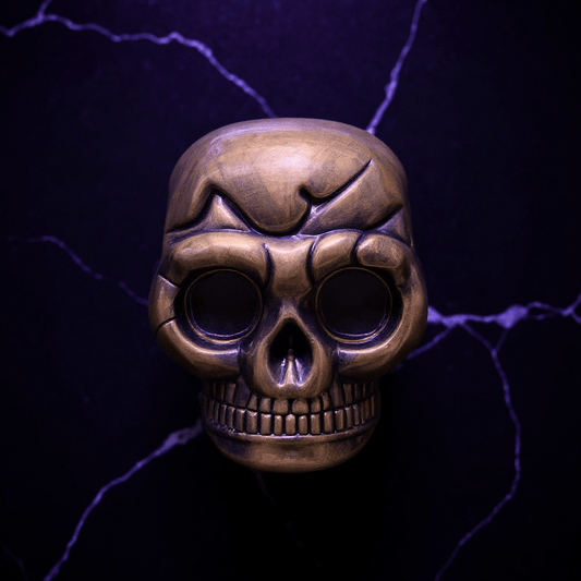Mini Skull Herb Grinder – Vintage Bronze - Bronze skull - shaped grinder on a dark background with purple lightning effects
