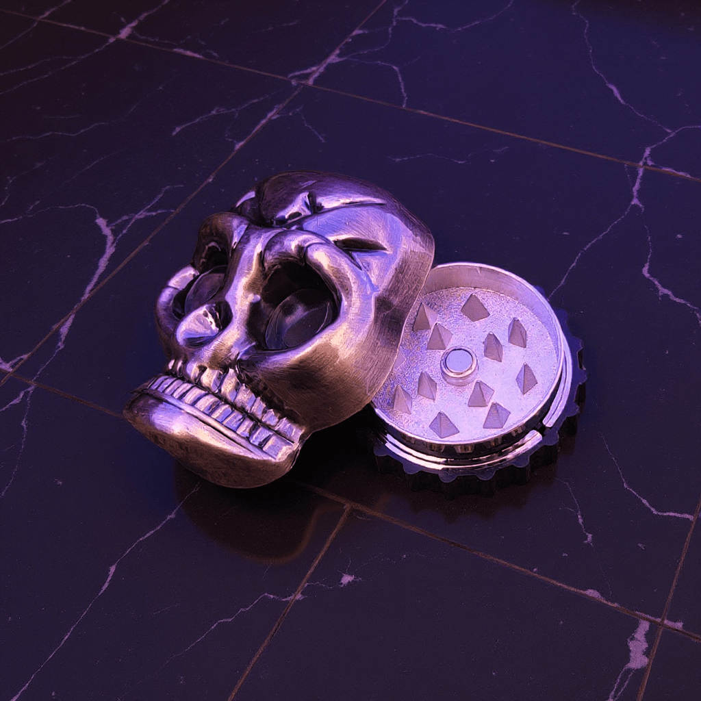 Mini Skull Herb Grinder – Vintage Bronze- Skull shaped herb grinders on a dark marble surface