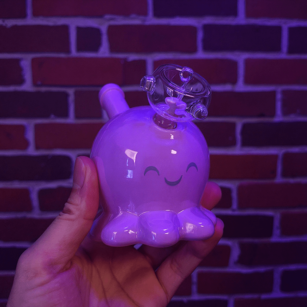 🐙 Octopus Bong - mini octopus glass bong for girlHand holding a purple octopus bong against a brick wall background