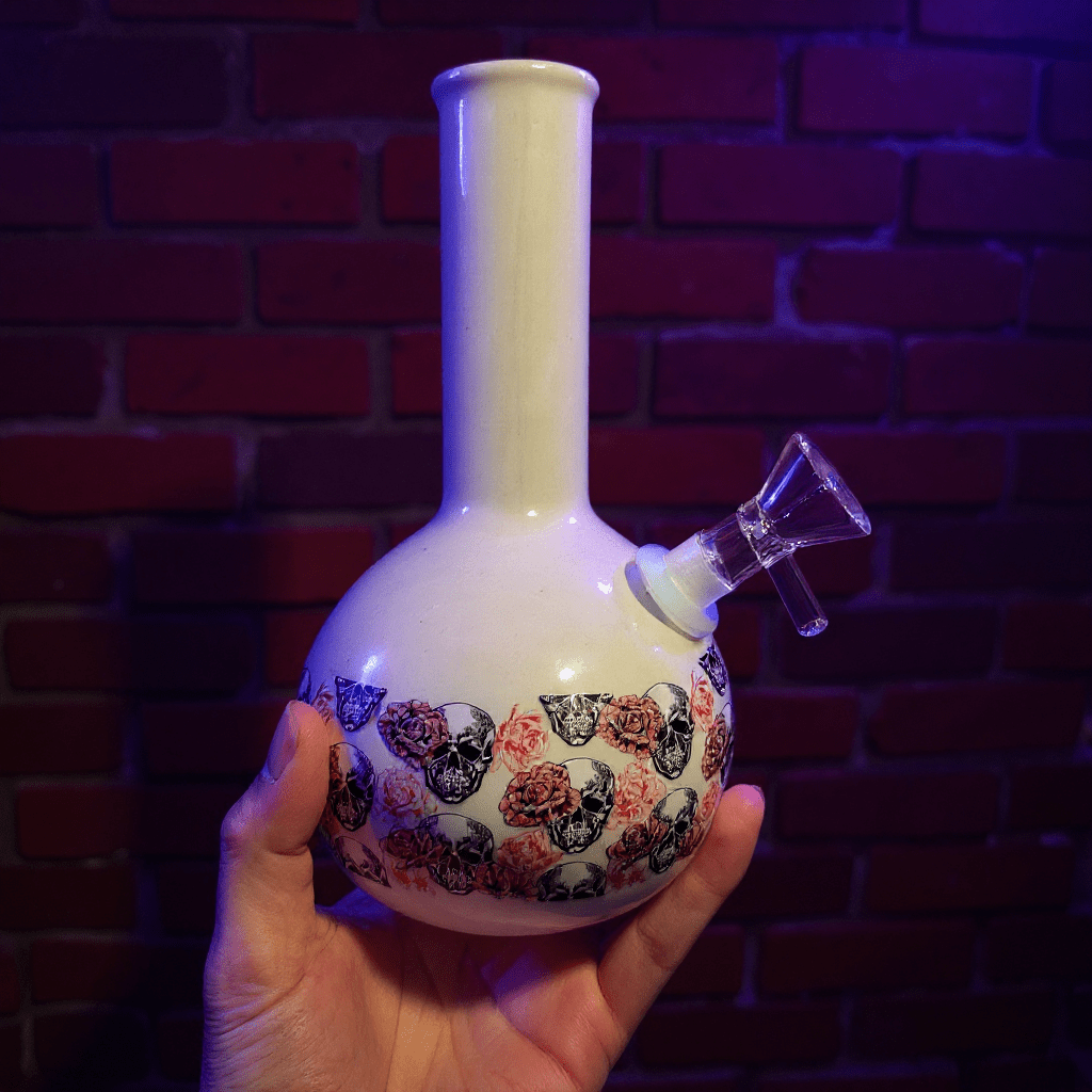 Skull & Roses Ceramic Bong – White Gothic Smoking Pipe - Hand holding a decorative ceramic bong with floral patterns