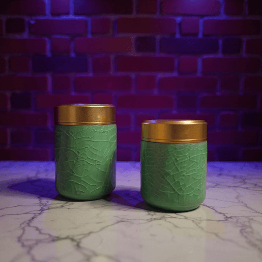 Smooth Green Celadon Porcelain Stash JarTwo green celadon porcelain stash jars with gold lids on a marble surface