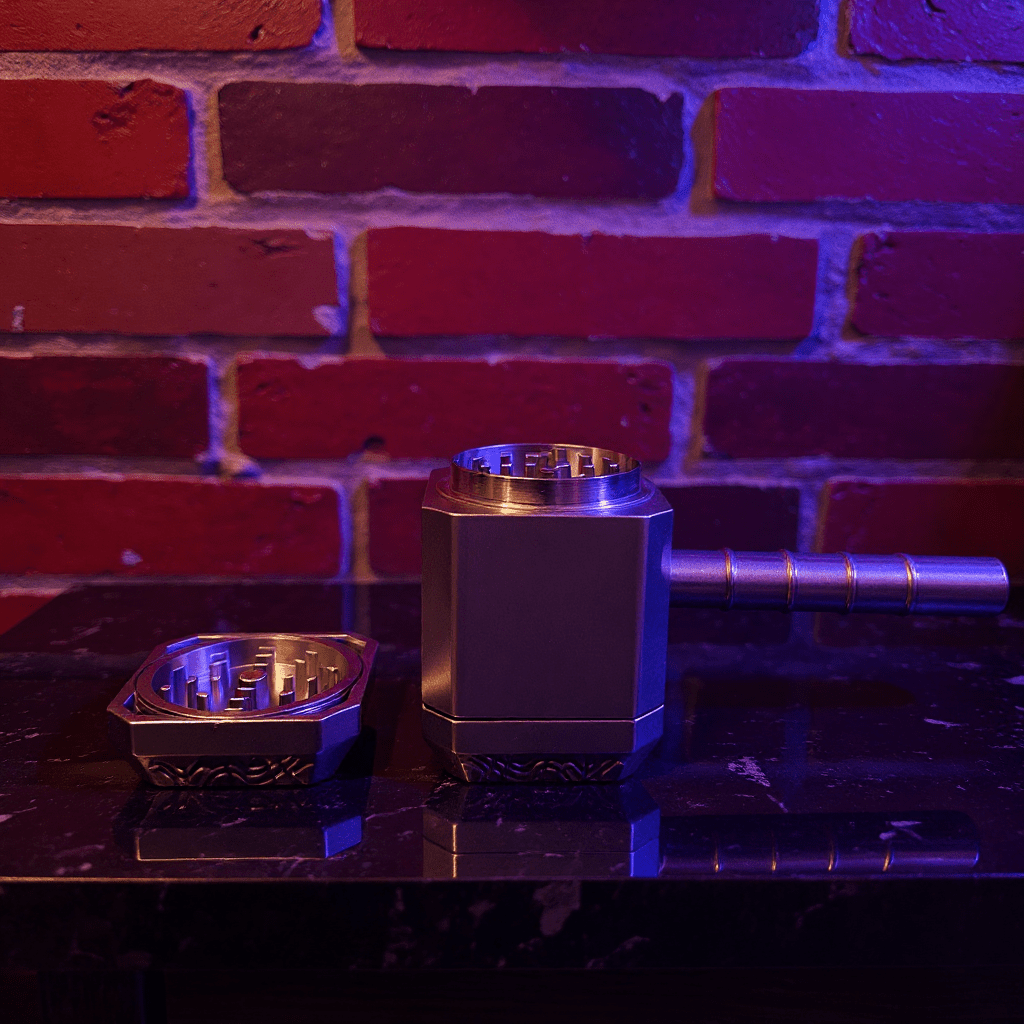Thor Hammer Shape Grinder – 4 - Part Metal Grindera hammer shape grinder is on a reflective surface with a brick wall background