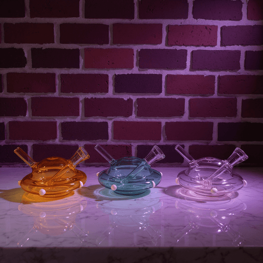 UFO Mini Glass Bong – Water Pipe in 3 ColorsThree glass smoking water pipe on a reflective surface