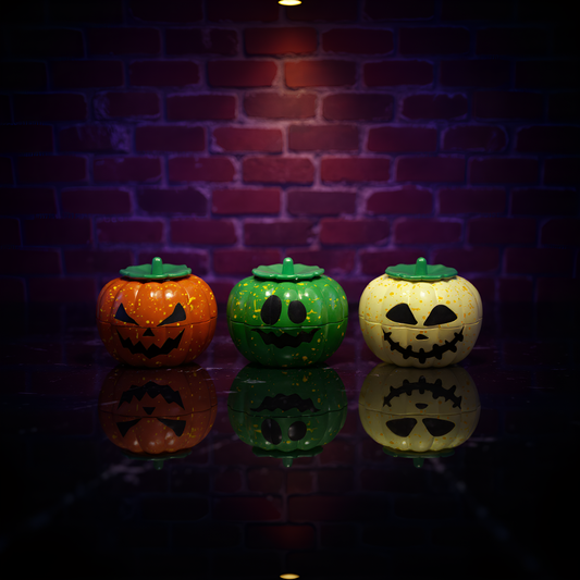Three colorful jack-o'-lanterns with green lids grinder on a reflective surface against a brick wall.
