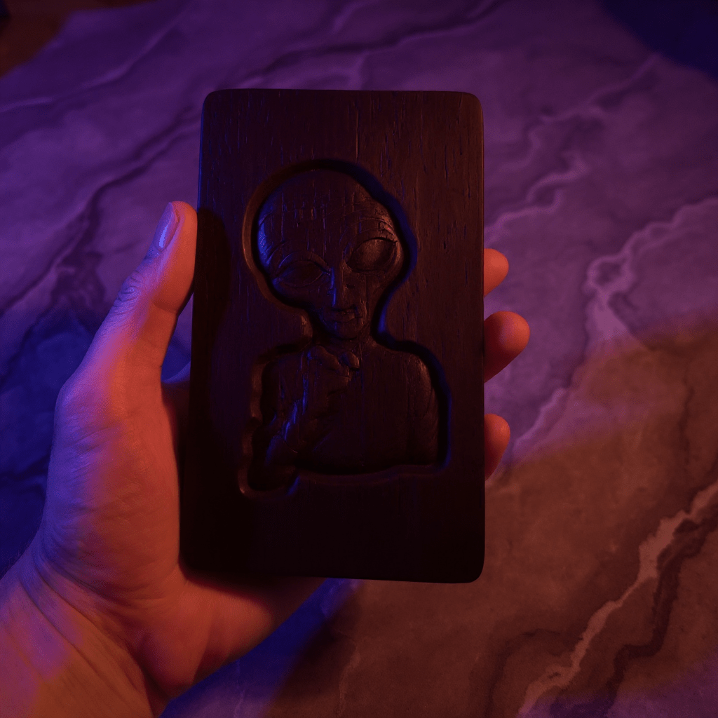 Alien Wooden Tobacco Box – Hand - Carved Secret Herb KeeperClose - up of hand holding a dark wood engraved alien box