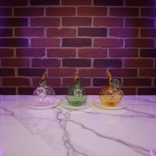 🍎 Apple Glass Bong – Mini Fruit Water PipeThree colorful glass bong on a marble surface with a brick wall background
