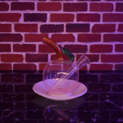 🍎 Apple Glass Bong – Mini Fruit Water PipeGlass apple - shaped pipe with wooden accent on a white plate