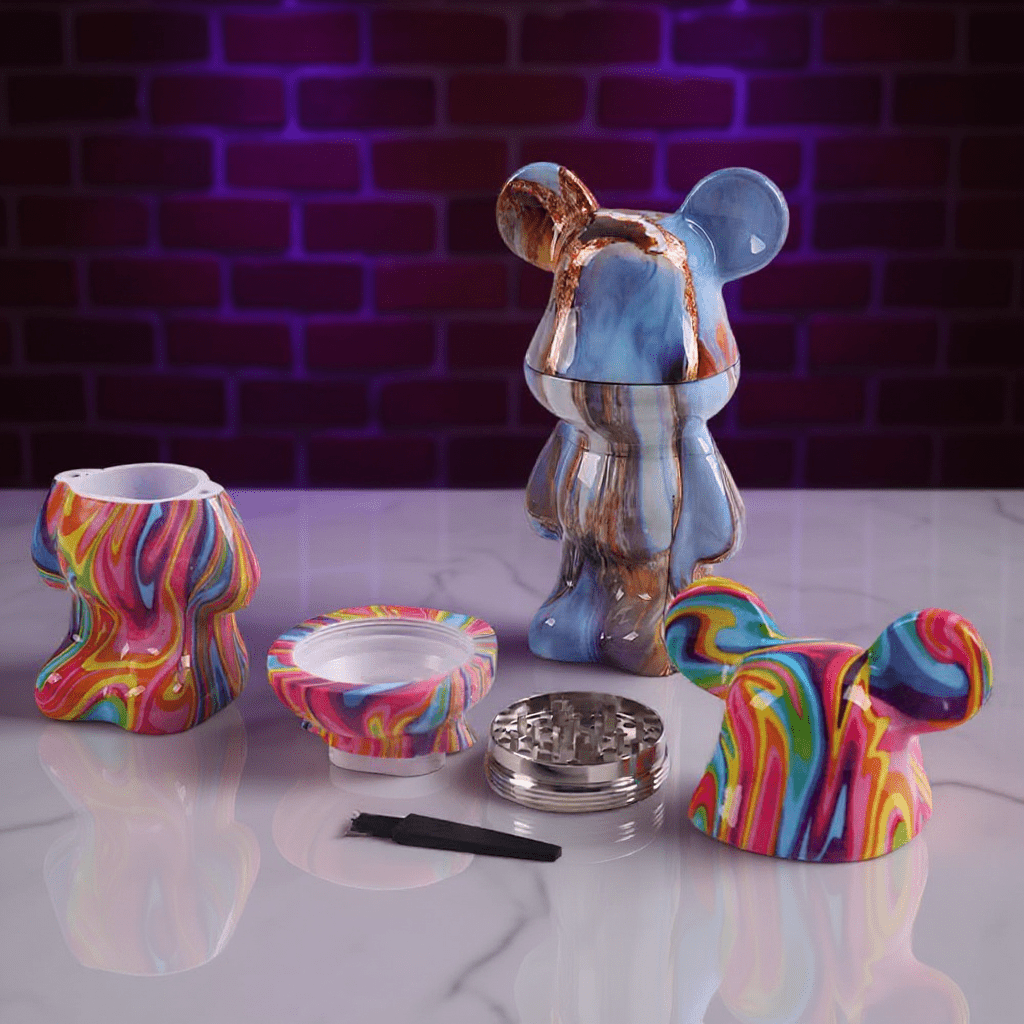 Bear Sculpture Herb Grinder - Colorful ceramic bear - shaped grinder and accessories on a reflective surface