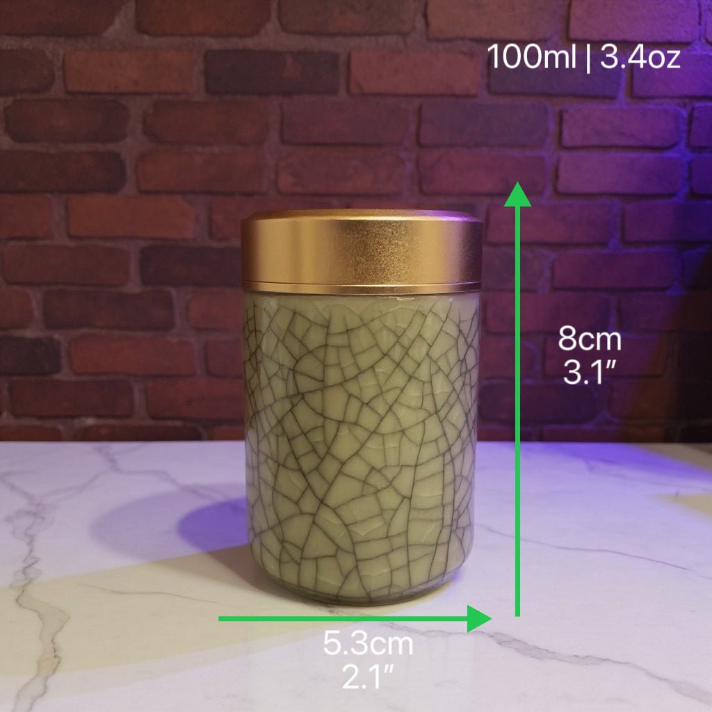 celadon porcelain jar with gold lid on a marble surface with measurements indicated.