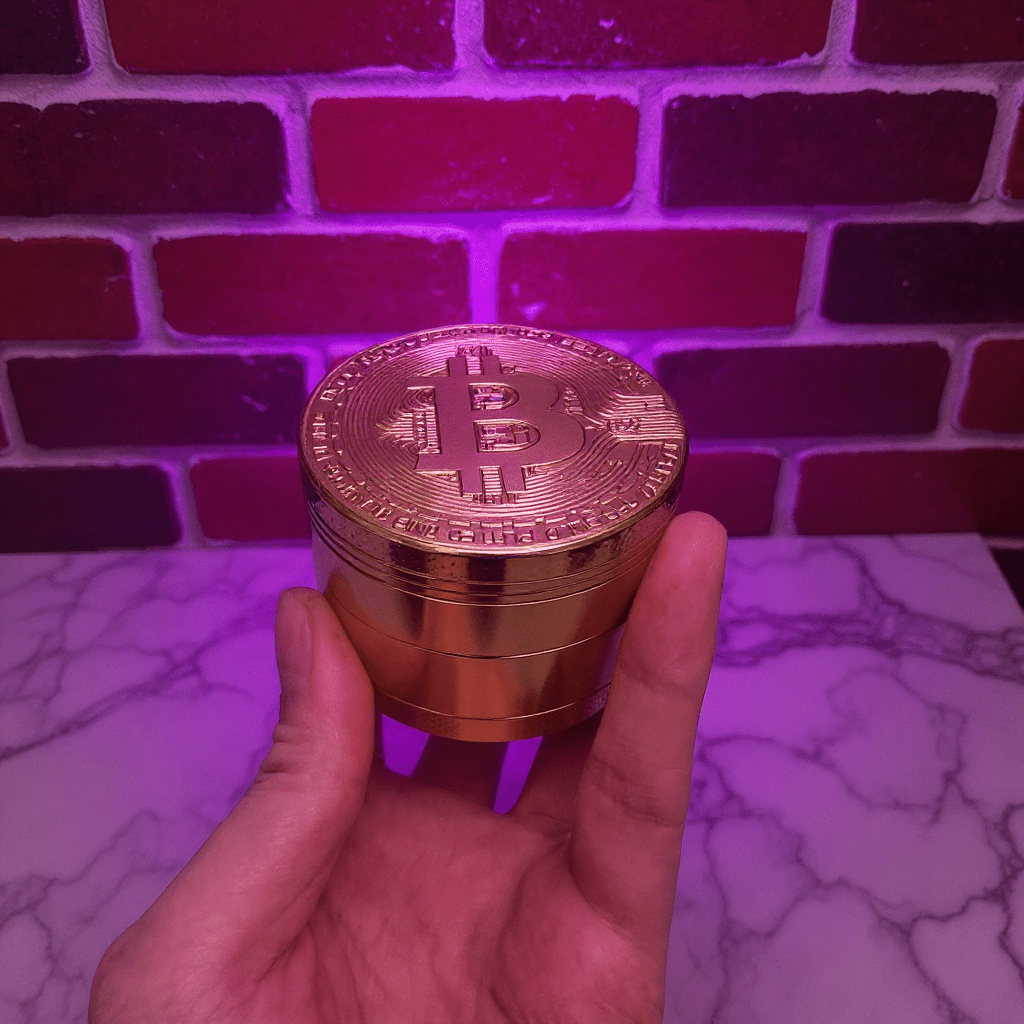 Bitcoin Herb Grinder – Gold Aluminum 4 - Piece Grinder - Gold - colored grinder with Bitcoin design held