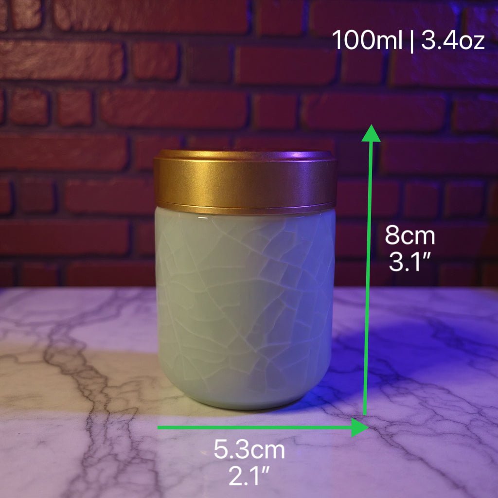 Celadon Porcelain Stash Jar – Light Green Ceramic Herb Storage ContainerGreen celadon porcelain jar with gold lid on a marble surface with measurements indicated.