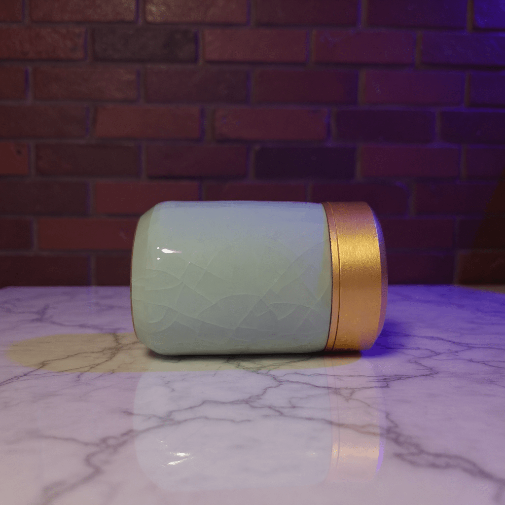 Celadon Porcelain Stash Jar – Light Green Ceramic Herb Storage Containerlight green celadon porcelain stash jar with gold lid on a marble surface