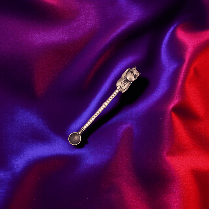 Cosmic Cat Duo Spoon SetMatte black cat - shaped herb spoon with mysterious charm on bold purple - red background.