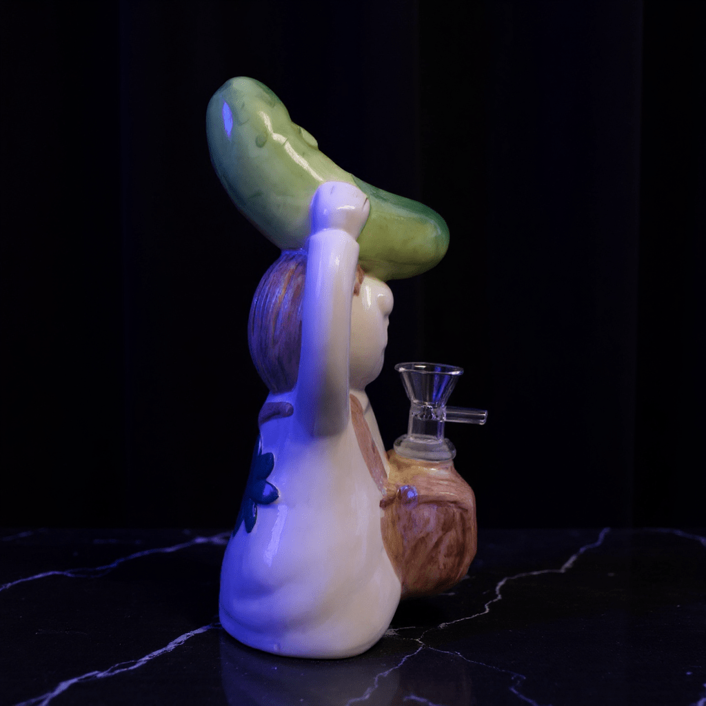 Cosmic Sidekick Ceramic Water PipeSide angle of ceramic pickle bong releasing smoke in a bedroom.