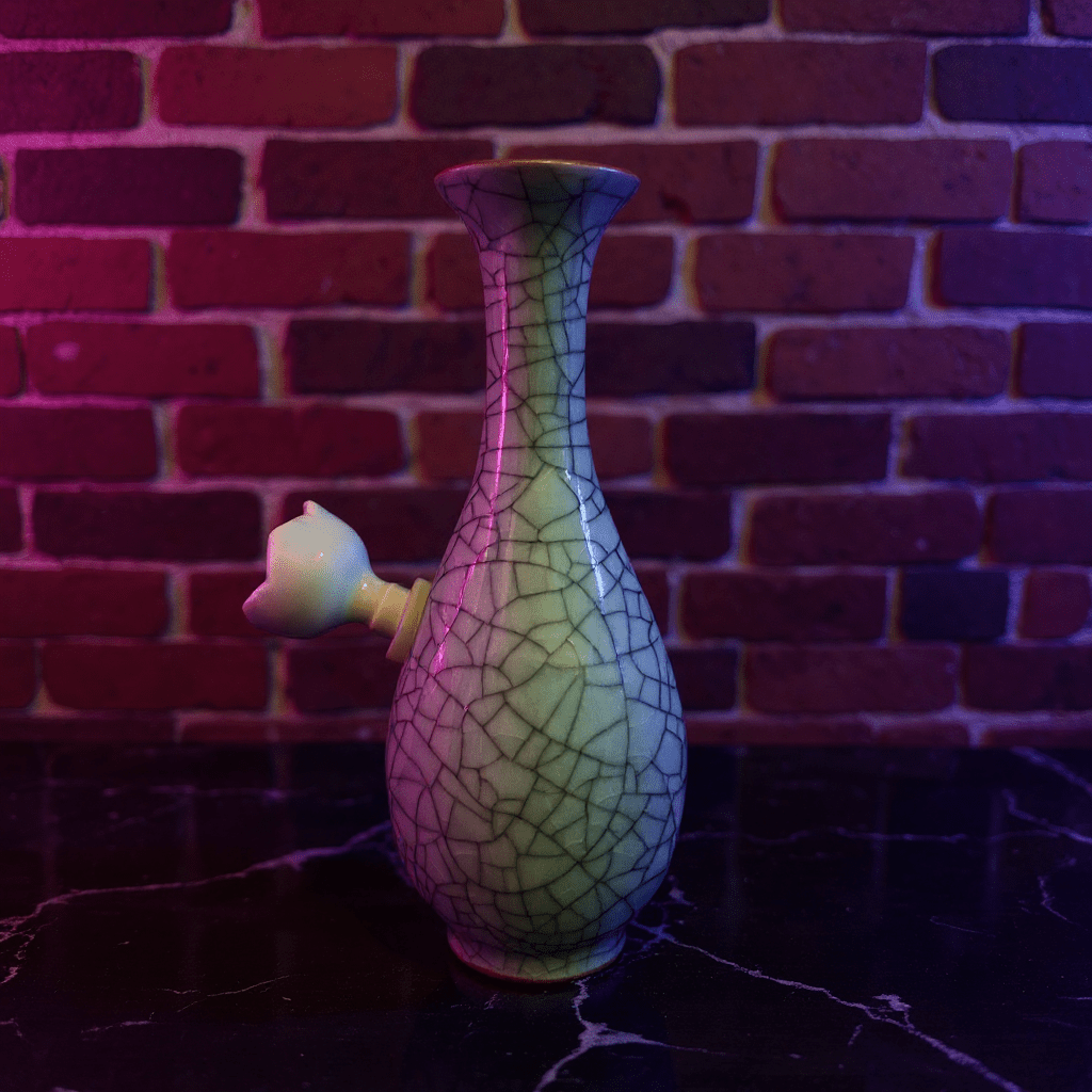Crackled Light Green Celadon Porcelain Bong – Elegant Ceramic BongDecorative porcelain bong with cracked ceramic design against a brick wall background