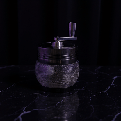 Crystal Hand Crank Herb Grinder - Elegant glass - textured grinder with metallic lid glowing under soft purple light.