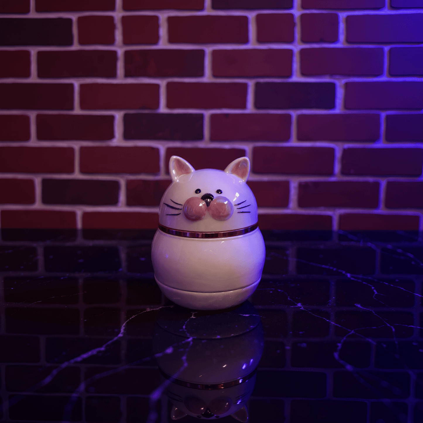 Cute Ceramic Cat Herb Grinder – Spice Crusher- White cat - shaped herb grinder night light on a reflective surface