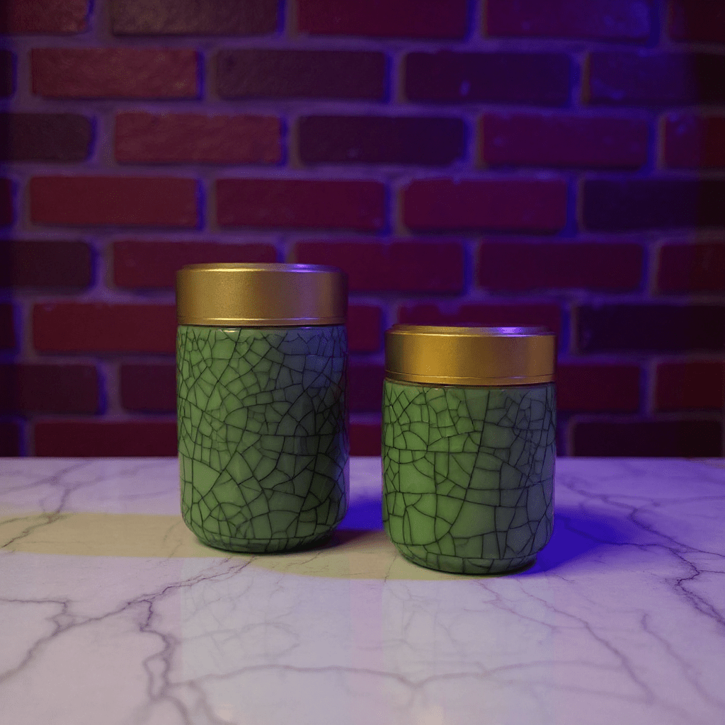 Deep Green Celadon Porcelain Stash Jar – Large & Small SizesTwo green celadon porcelain jars with gold lids on a marble surface