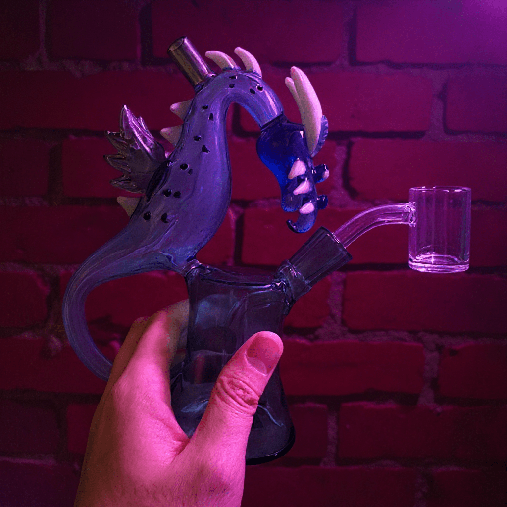 Dragon Rider Glass Bong - Dragon Beaker Water PipeGlass smoking bong shaped like a dragon held by hand against a brick wall.