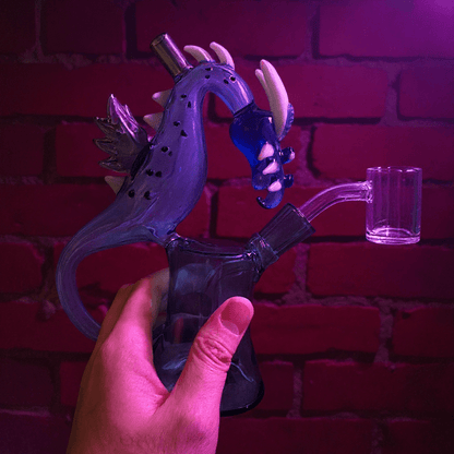 Dragon Rider Glass Bong - Dragon Beaker Water PipeGlass smoking bong shaped like a dragon held by hand against a brick wall.