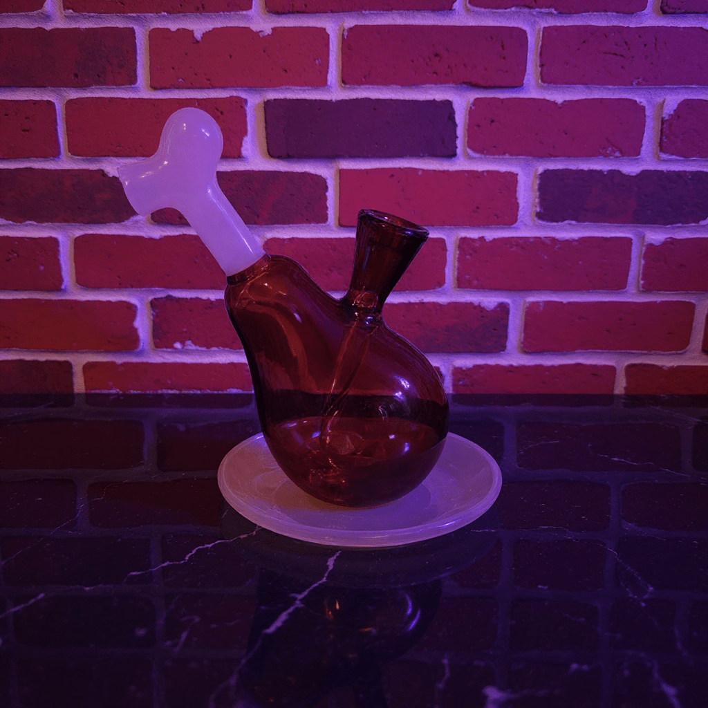 Drumstick Glass Bong – Mini Turkey Leg Water Pipe - Glass bong with a white cap on a round white platform