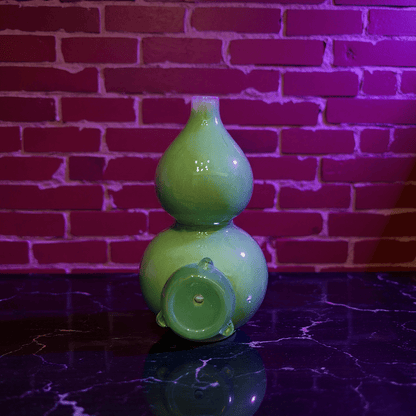 Glossy Green Celadon Gourd Porcelain BongGreen ceramic bong with glass bong on a reflective surface