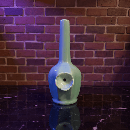 Glossy Light Blue Celadon Flat - Sided Porcelain BongGlossy Light Blue Celadon Flat - Sided Porcelain Bong with ceramic bowl is placed on a marble surface.