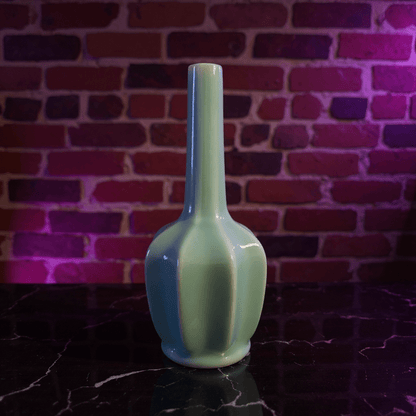 Glossy Light Blue Celadon Flat - Sided Porcelain BongGreen ceramic bong on a dark surface with a brick wall background