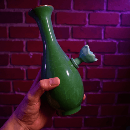 Green Ice - Crack Celadon Porcelain Bong with Flared TopGreen ceramic bong with ceramic bowl held by hand against a brick wall